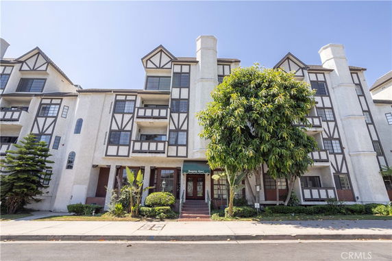 Front view of a multi-story residential building with Tudor-style architecture.