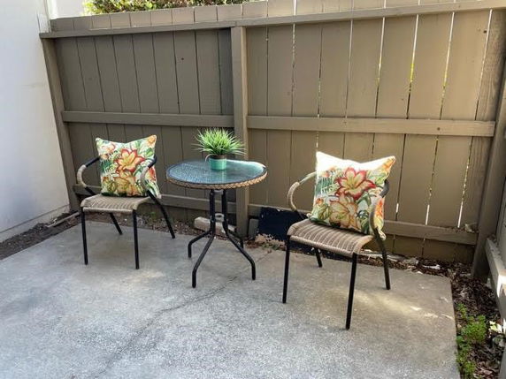 Outdoor patio area with two chairs and a small table.