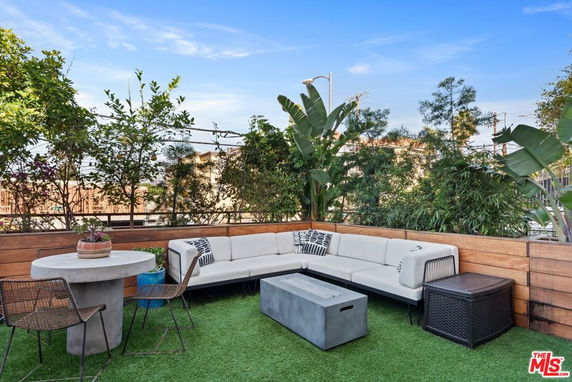 Rooftop with seating area and greenery.
