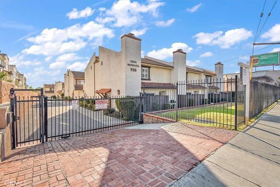 Front view of a multi-story residential building with gated entrance.
