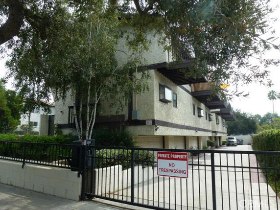 Front view of a multi-story residential building with gated entrance.