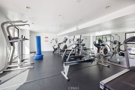Indoor gym area with exercise equipment and mirrors.