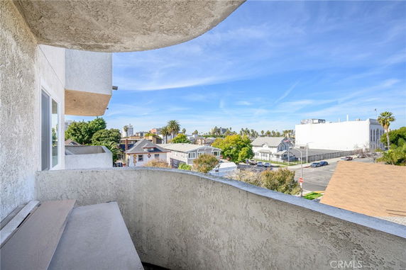 View from a building balcony overlooking neighboring rooftops and streets.