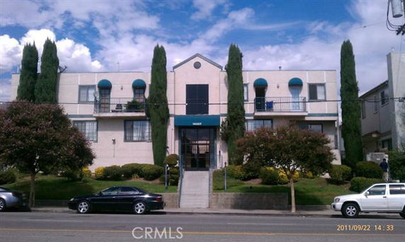 Front view of a two-story residential building with a symmetrical design and entrance stairs.