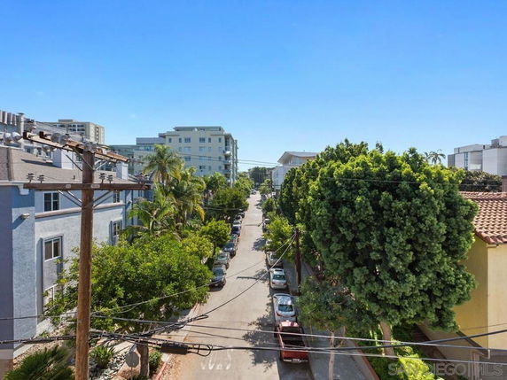 View of buildings and trees lining a street.