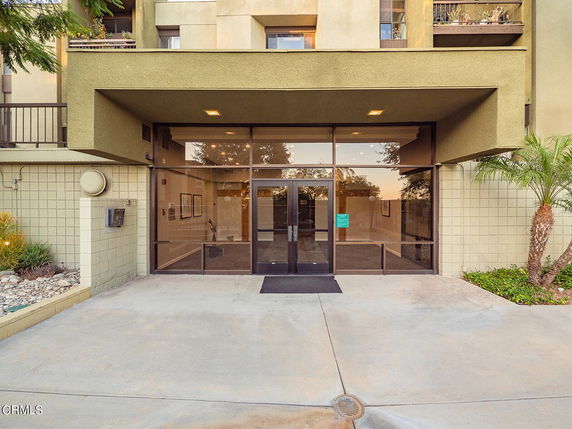 Entrance of a building with glass doors and a concrete exterior.