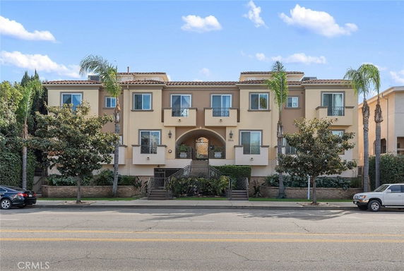 Front view of a multi-story residential building with an arched entrance.