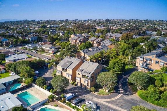 Aerial view of residential area with multiple buildings and surrounding greenery.