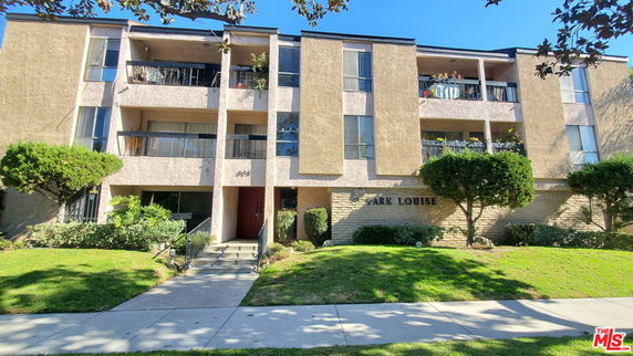 Front view of a multi-story apartment building with balconies.
