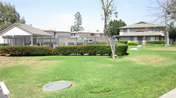 Front view of a residential complex with a two-story building and a fenced area.