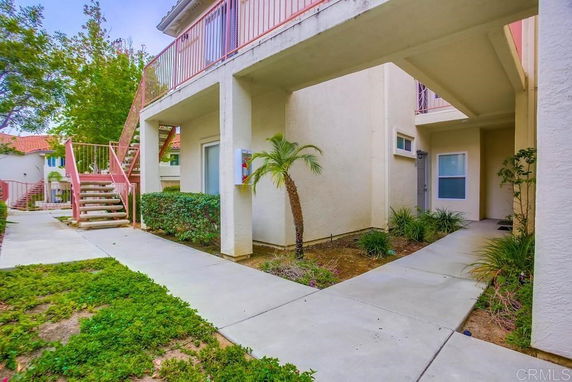 Front view of an apartment building with exterior staircases and walkways.