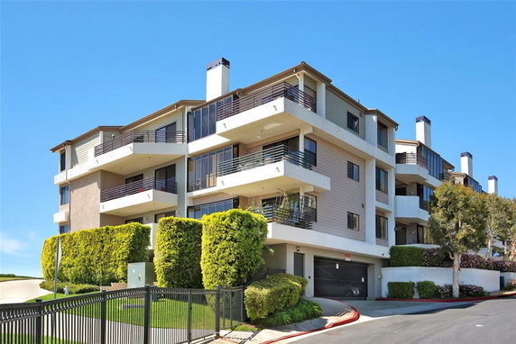 Front view of a multi-story apartment building with balconies.