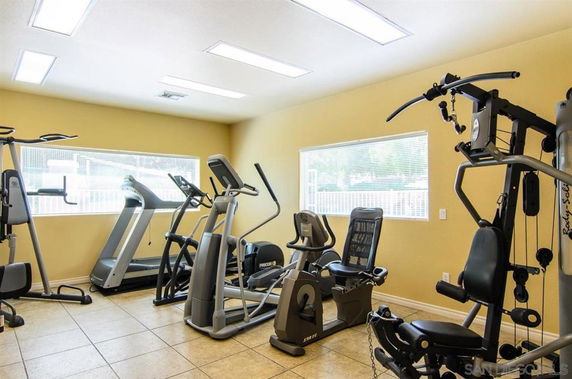 Indoor gym area with exercise machines and equipment.