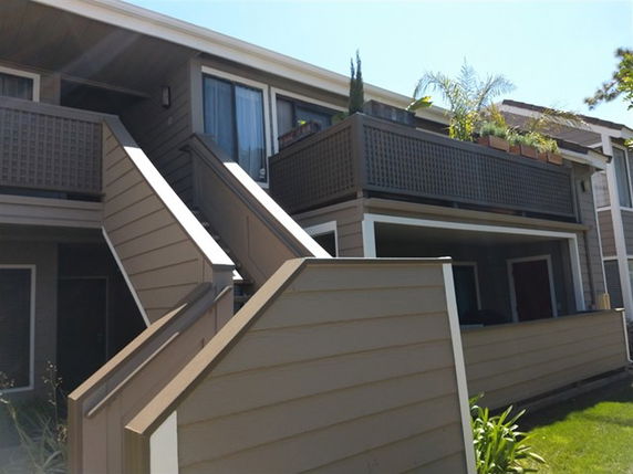 View of a two-story building with external stairs and balconies.