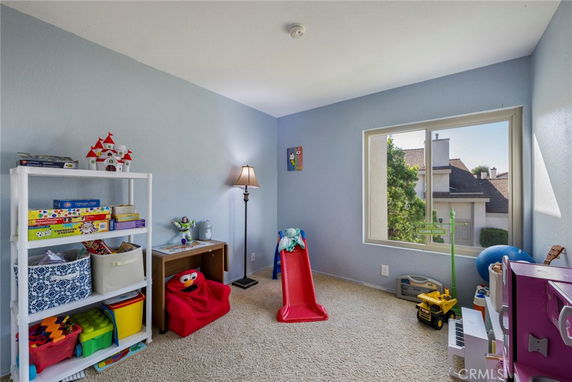 Children's play area with toys, slide, and shelves inside a room.
