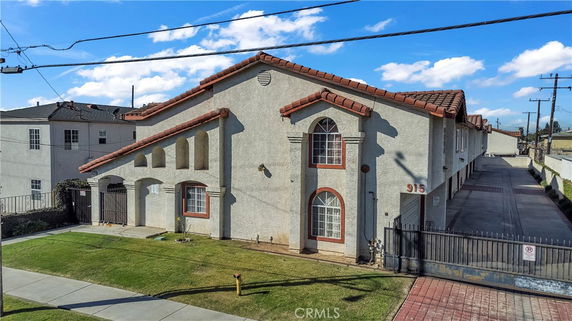 Front view of a two-story building with arched windows and a gated entrance.