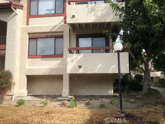 Front view of a multi-story building with balconies and large windows.