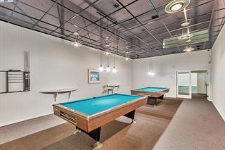 Interior view of a room with two billiard tables and overhead lighting.