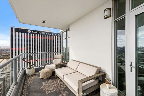 Balcony view with seating area overlooking a cityscape and California Bank & Trust building.