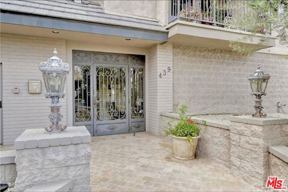 Front view of a building entrance with ornate metal gate and decorative lanterns.