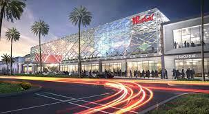 Front view of a large commercial building with a modern glass facade and decorative lighting.