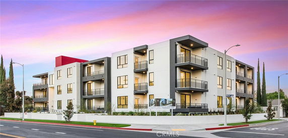 Front view of a modern multi-story apartment building with balconies.