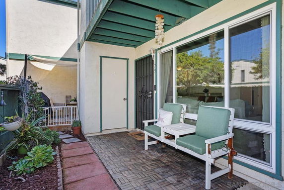 Front view of a two-story house with a small outdoor seating area.