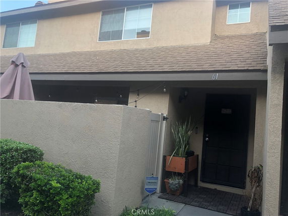 Front view of a two-story house with a small patio area.