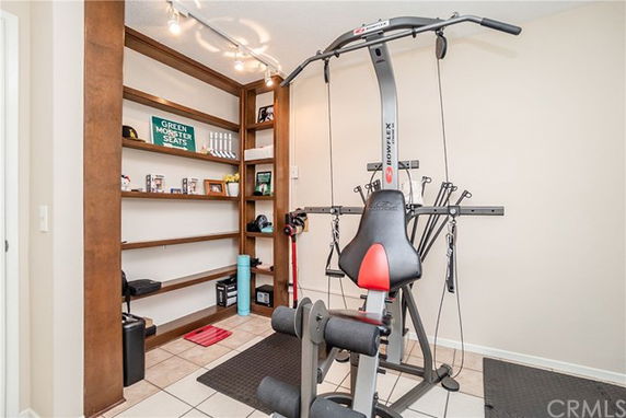 Indoor gym area with exercise equipment and shelving.