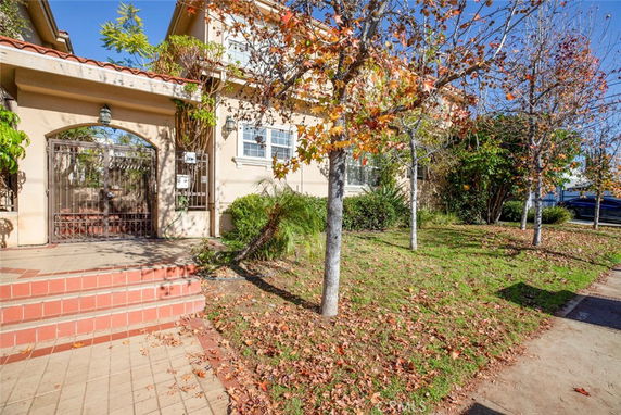 Front view of a house with a tiled entryway and gated entrance.