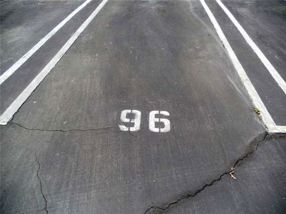 Numbered parking space on an asphalt surface.
