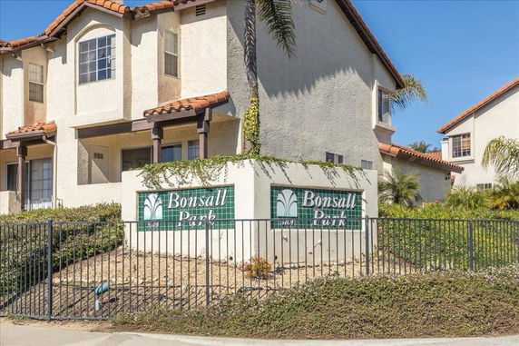 Front view of a multi-story residential building with a sign labeled 'Bonsall Park'.