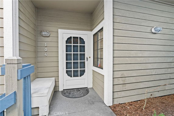 Front entrance of a house with a covered porch and door number 104.