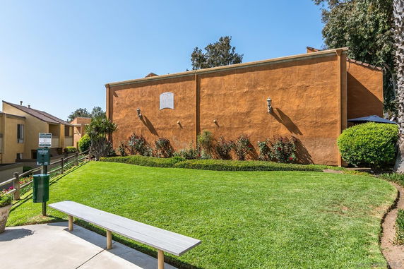 Front view of a building with a flat exterior and vegetation in front.
