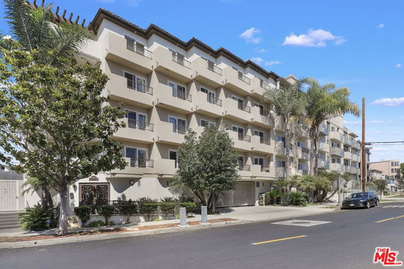 Front view of a multi-story apartment building with balconies.