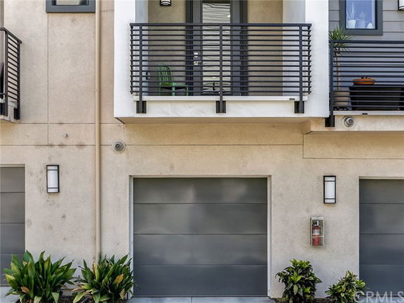 Front view of a modern house with a balcony and a garage door.