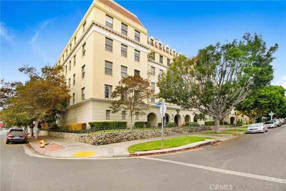 Front view of a multi-story apartment building on a street corner.