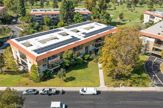 Aerial view of a multi-story building with solar panels on the rooftop.