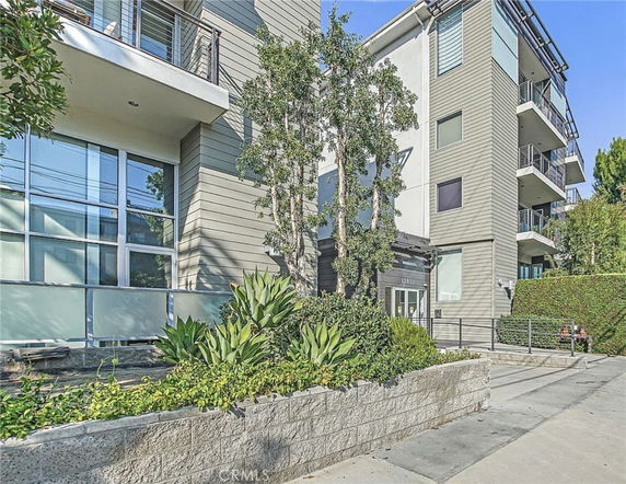 Front view of a modern multi-story apartment building with balconies.