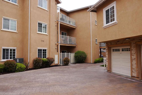 Front view of a multi-story residential building with balconies and driveways.