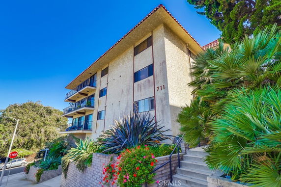 Front view of a multi-story apartment building with balconies.