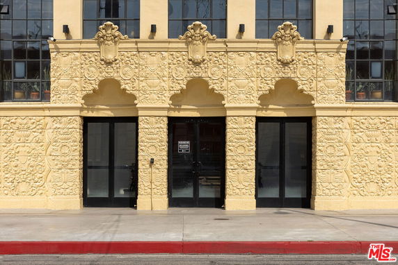Front view of a building with ornate decorative facade and large glass windows.