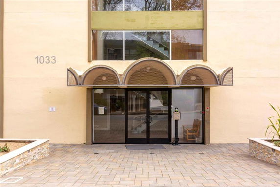 Entrance view of a building with glass doors and decorative canopy.