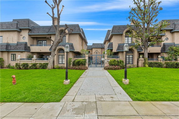 Front view of a multi-story residential building with landscaped entrance.