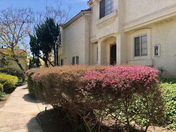 Front view of a multi-story house with stucco exterior.