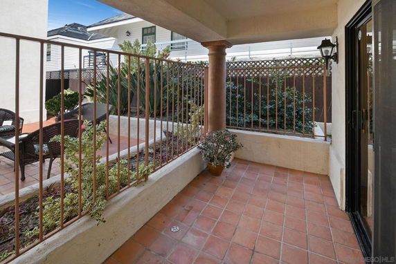 Outdoor patio space with terracotta tiles and surrounding garden area.