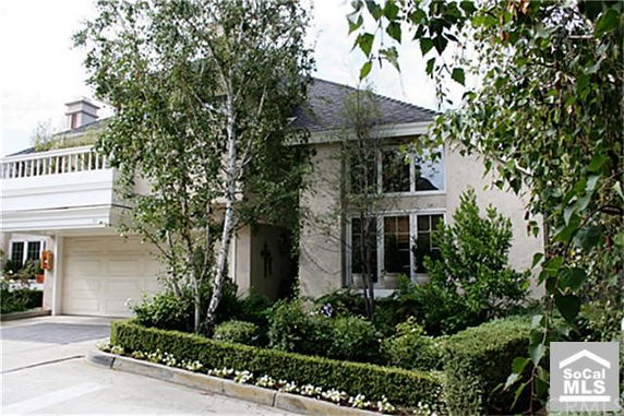 Front view of a two-story house with a garage and a small garden area.