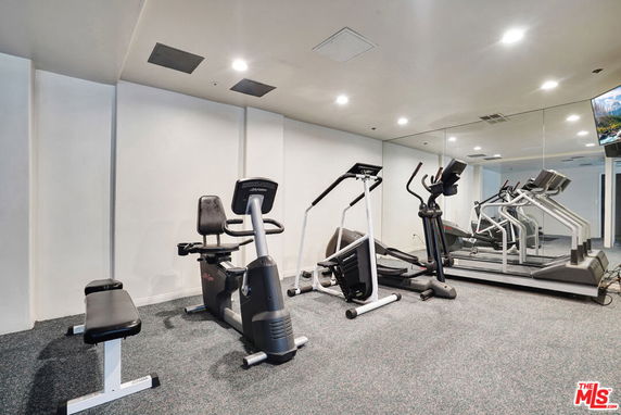 Indoor gym area with exercise equipment and mirrors.
