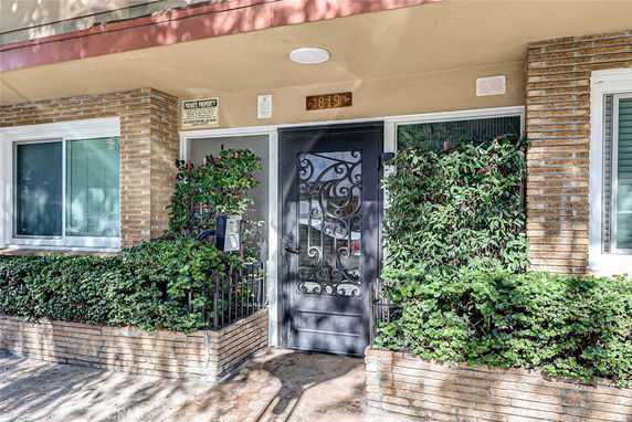 Front view of a building entrance with decorative door and brick facade.