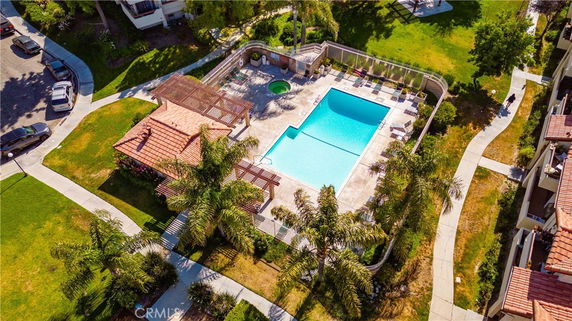 Aerial view of a swimming pool surrounded by greenery and buildings.